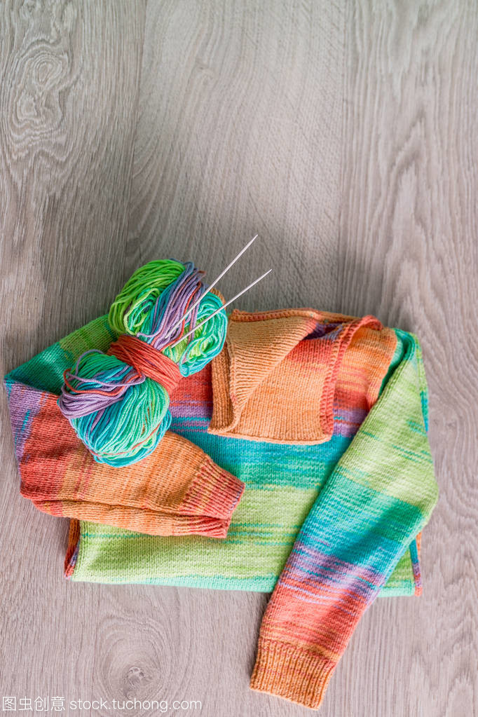 針織。針織毛衫。多色球的紗線用針附近上木制的灰色背景的手工產品。頂視圖。復制空間